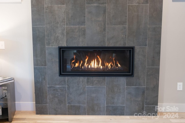 room details with hardwood / wood-style flooring and a tile fireplace