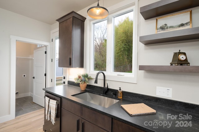 kitchen with sink, decorative light fixtures, dark brown cabinets, and light wood-type flooring