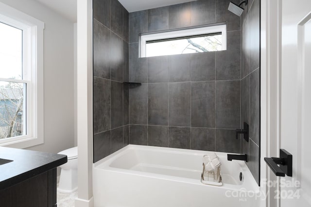 full bathroom with vanity, toilet, and tiled shower / bath combo