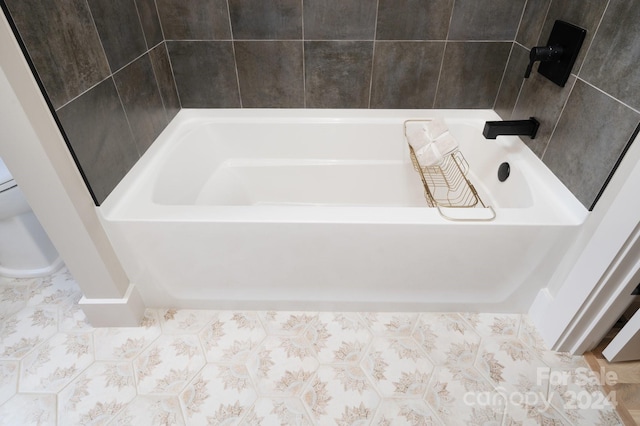 bathroom with a bath and tile patterned floors