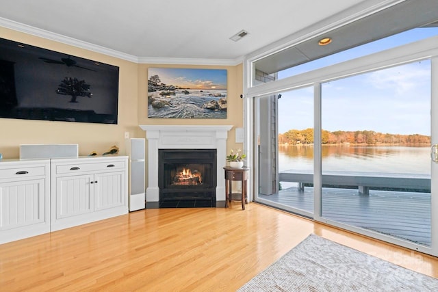 living room with crown molding, a water view, and light hardwood / wood-style floors