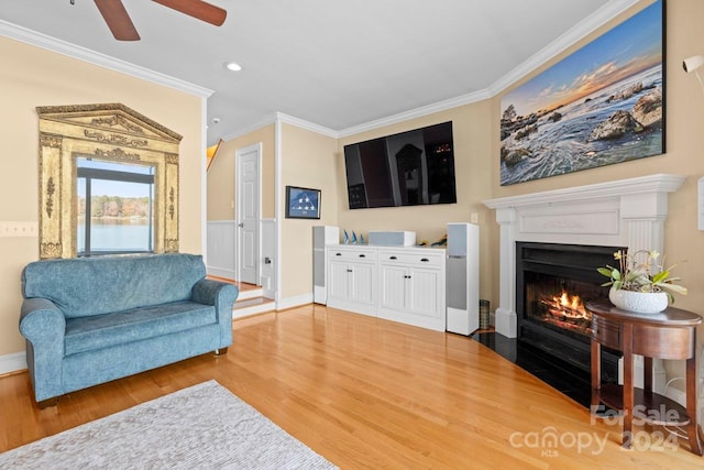 living room with hardwood / wood-style flooring, ceiling fan, and ornamental molding