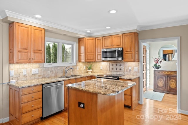 kitchen with tasteful backsplash, a center island, stainless steel appliances, and light wood-type flooring