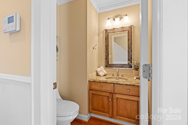 bathroom featuring hardwood / wood-style floors, vanity, toilet, and crown molding