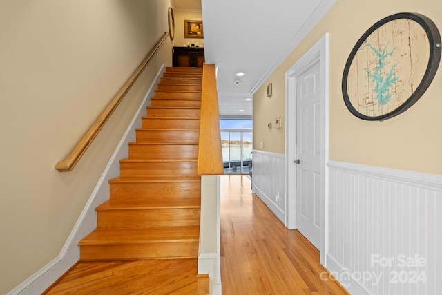 stairway featuring hardwood / wood-style floors and crown molding