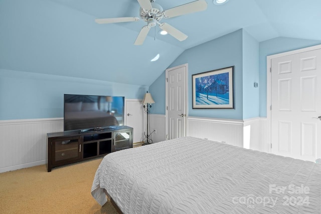 bedroom featuring light colored carpet, vaulted ceiling, and ceiling fan