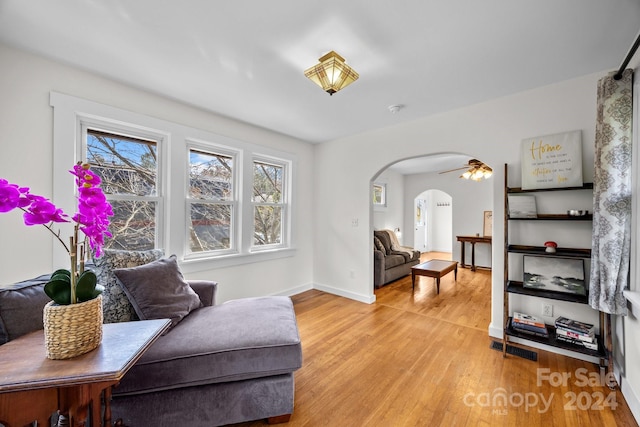 living area with light hardwood / wood-style floors and ceiling fan