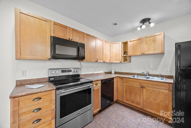 kitchen featuring light brown cabinetry, sink, light tile patterned floors, and black appliances