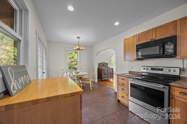 kitchen with butcher block countertops, decorative light fixtures, stainless steel range with electric stovetop, and a notable chandelier