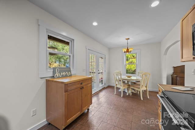 tiled dining room with a chandelier and french doors