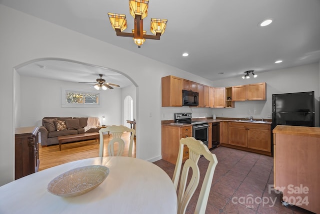 tiled dining space with ceiling fan with notable chandelier and sink