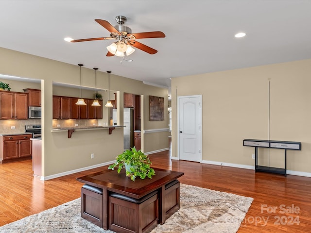 living room with ceiling fan and hardwood / wood-style flooring