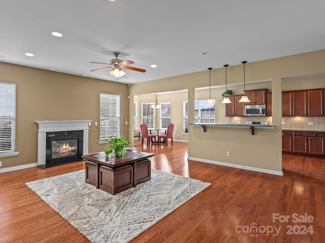 living room with a wealth of natural light and dark wood-type flooring