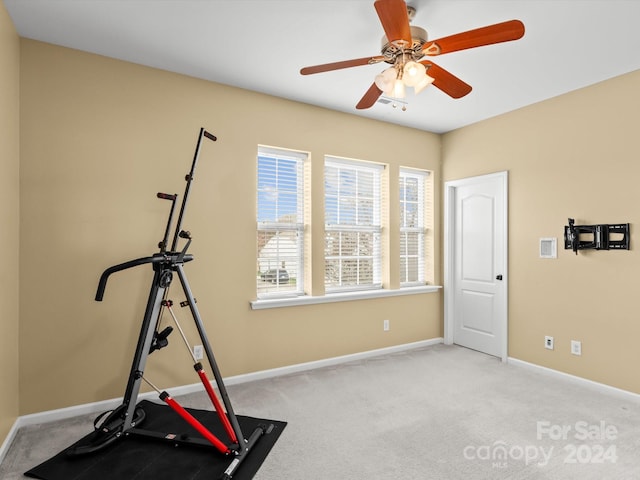 workout room featuring ceiling fan and light colored carpet