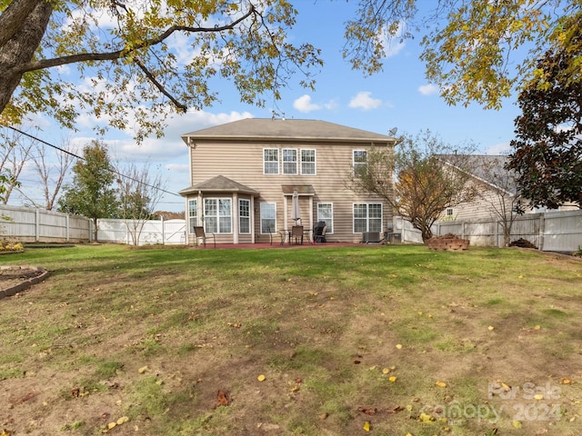 back of house featuring central AC unit, a patio area, and a yard