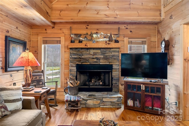 living room featuring hardwood / wood-style floors, a fireplace, and wooden walls