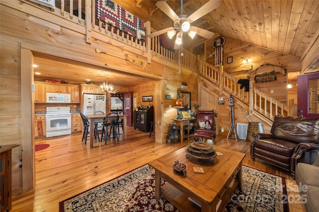 living room featuring wood ceiling, light hardwood / wood-style flooring, high vaulted ceiling, ceiling fan with notable chandelier, and wood walls