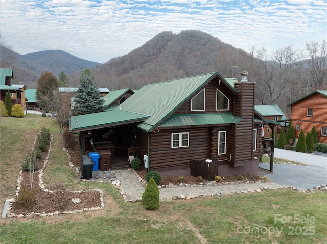 view of front of house featuring a mountain view and a front lawn