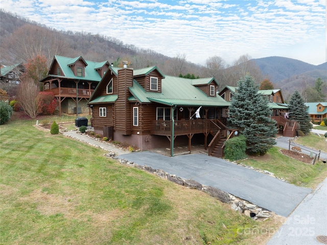 log cabin with a mountain view, a front yard, central air condition unit, and a porch