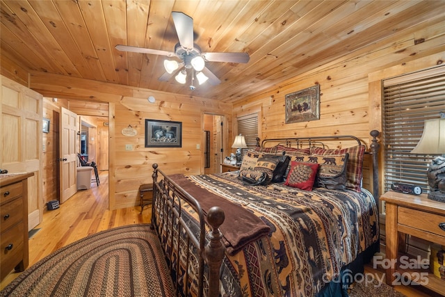 bedroom with wood walls, wood ceiling, and light hardwood / wood-style flooring