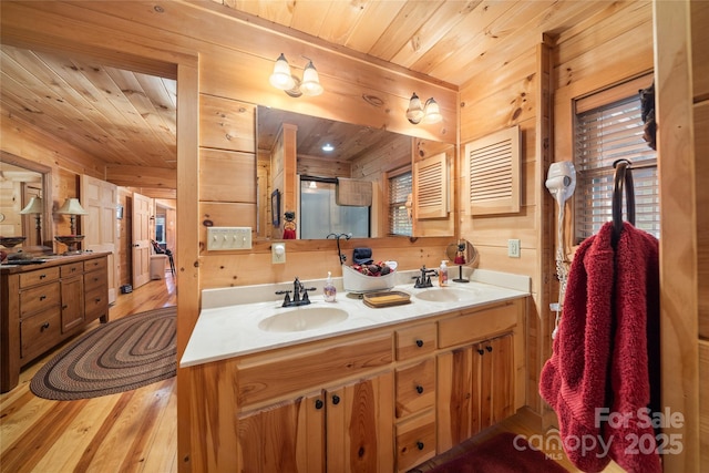 bathroom with vanity, hardwood / wood-style floors, wood ceiling, and wooden walls