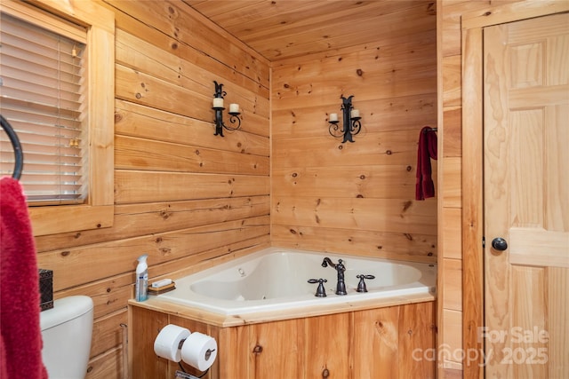 bathroom with a bathtub, wooden walls, and toilet