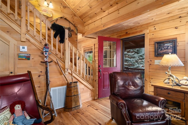 sitting room featuring wood ceiling, wooden walls, light hardwood / wood-style floors, and vaulted ceiling