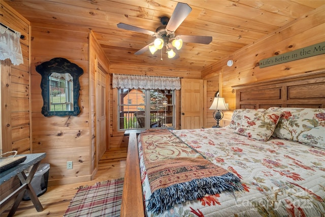 bedroom featuring ceiling fan, wooden ceiling, wooden walls, and light wood-type flooring