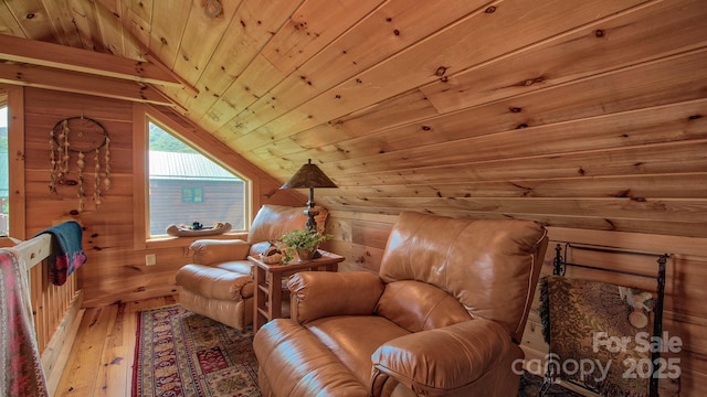 sitting room featuring vaulted ceiling, wooden ceiling, hardwood / wood-style floors, and wood walls