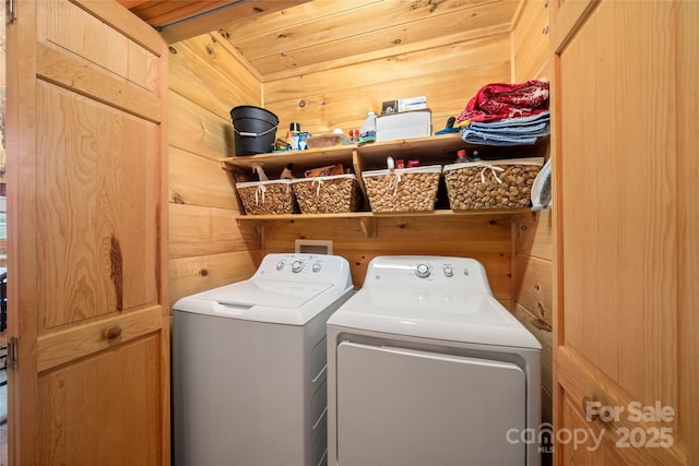 laundry area featuring wooden walls, wooden ceiling, and washer and dryer