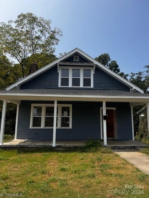 view of front of home featuring covered porch and a front yard