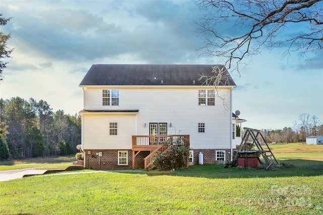 back of house featuring a lawn and a wooden deck