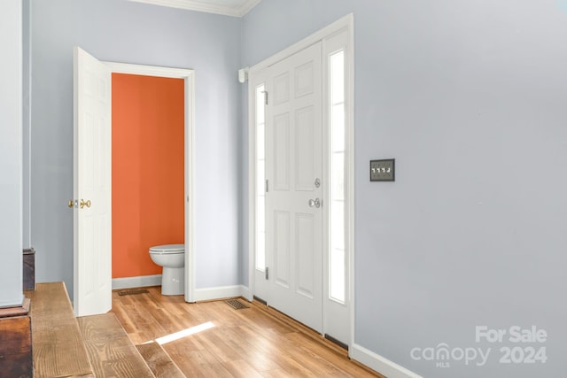 entryway with light hardwood / wood-style floors and ornamental molding