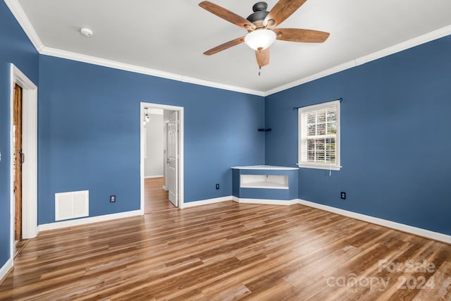 unfurnished bedroom featuring hardwood / wood-style flooring, ceiling fan, and crown molding
