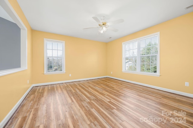unfurnished room featuring ceiling fan, light hardwood / wood-style floors, and a wealth of natural light