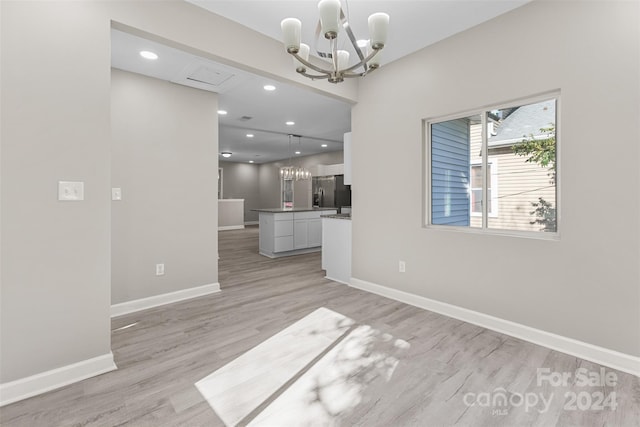 interior space with light hardwood / wood-style flooring and a notable chandelier