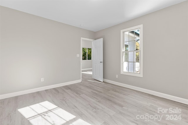 spare room with plenty of natural light and light hardwood / wood-style flooring