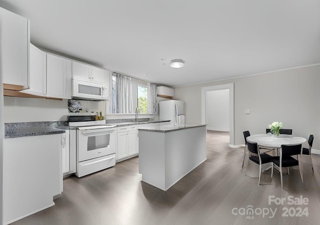 kitchen featuring white appliances, dark hardwood / wood-style floors, white cabinetry, and sink