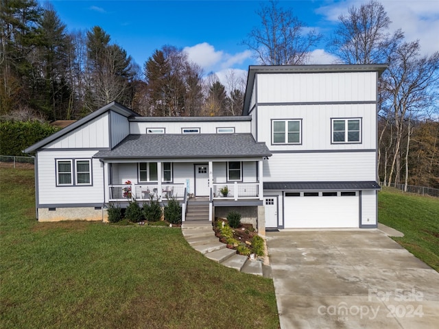 view of front of house with a front yard, a porch, and a garage