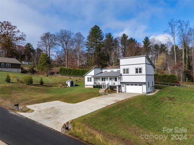 view of front of property with covered porch, a garage, and a front yard