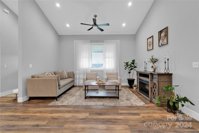 living room with ceiling fan, wood-type flooring, and lofted ceiling