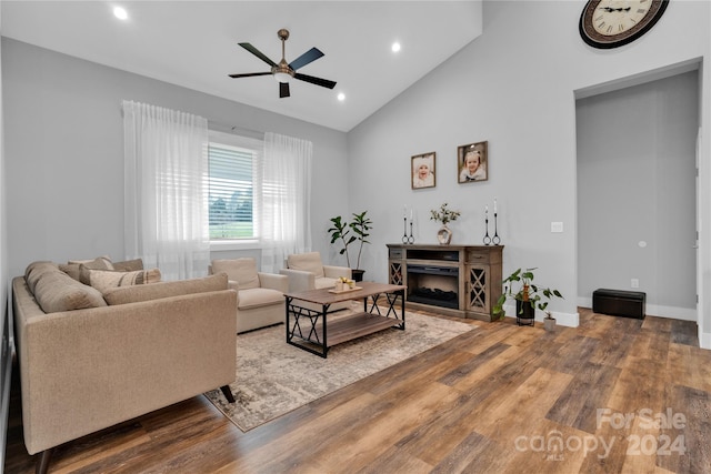 living room with ceiling fan, a fireplace, high vaulted ceiling, and hardwood / wood-style flooring