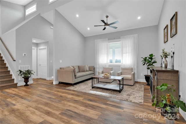 living room featuring ceiling fan, high vaulted ceiling, and wood-type flooring