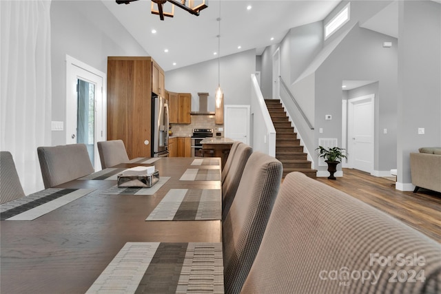 dining area featuring dark wood-type flooring and high vaulted ceiling