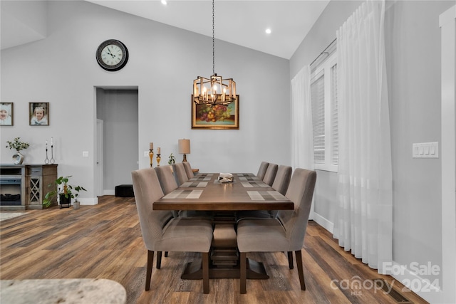 dining room featuring dark hardwood / wood-style flooring, high vaulted ceiling, and a notable chandelier