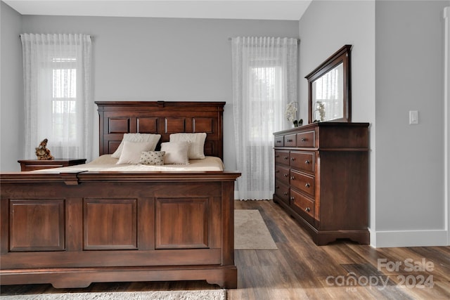 bedroom with dark hardwood / wood-style flooring