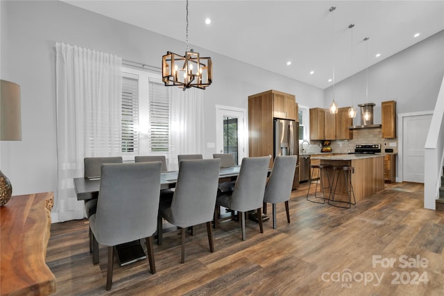 dining area featuring a chandelier, high vaulted ceiling, dark wood-type flooring, and sink