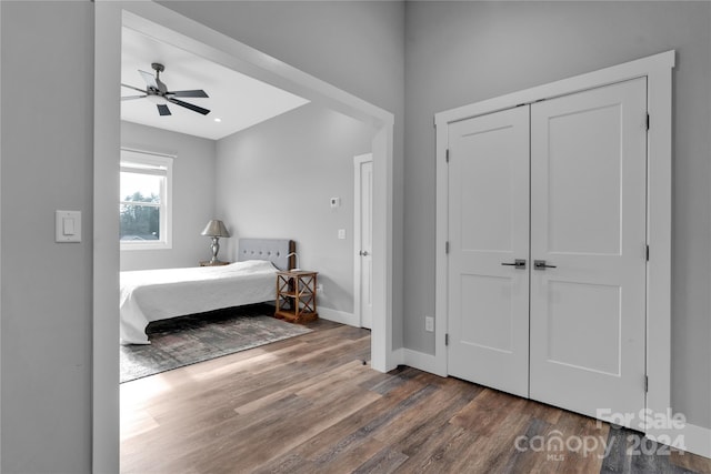 bedroom with ceiling fan, dark wood-type flooring, and a closet