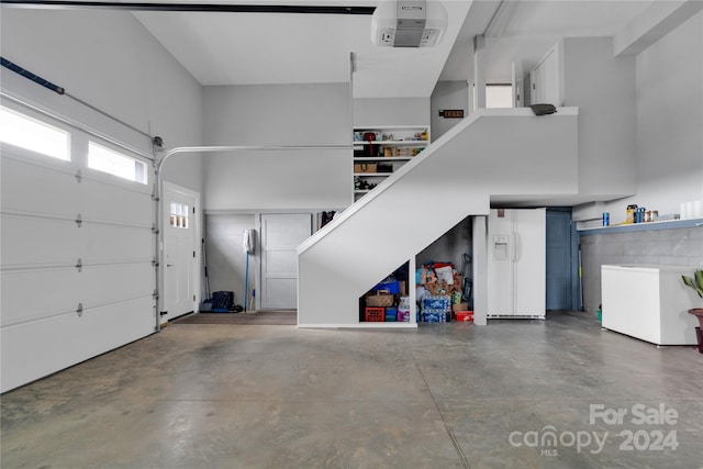 garage featuring white fridge with ice dispenser