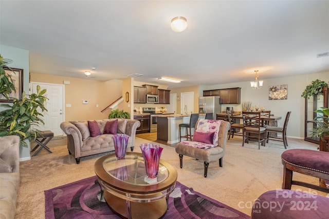 living room with a chandelier, light colored carpet, and sink